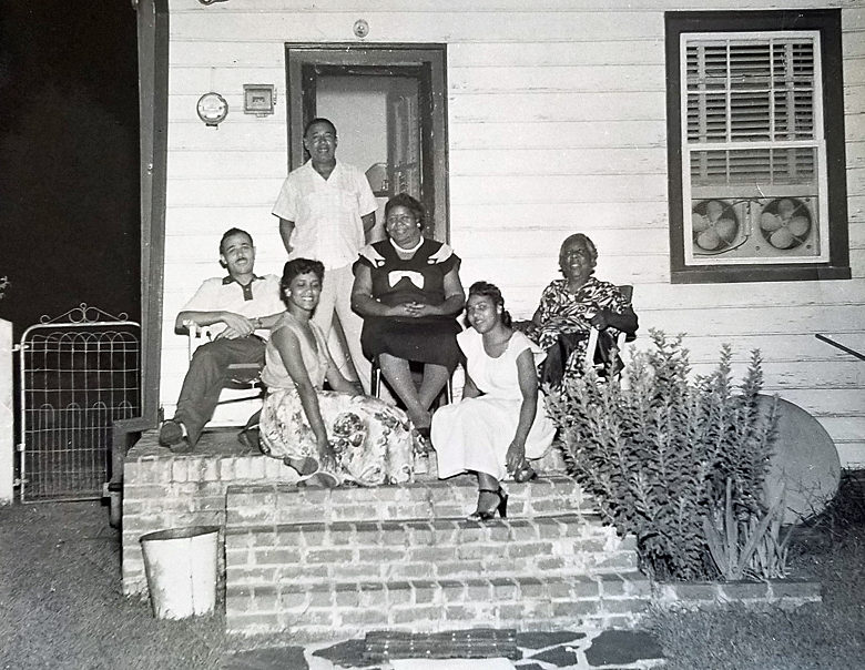 Photo by black photographer of African Americans sitting on porch.