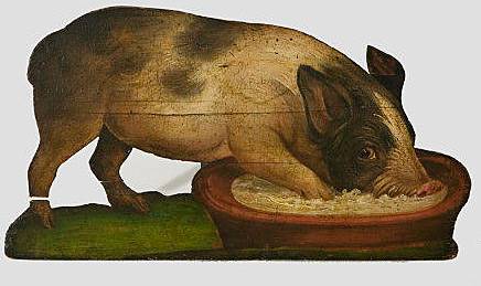 A dummy board of a pig eating from a bowl. 