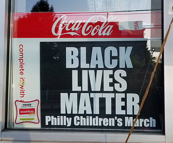 A "Black Lives Matter" sign in a corner shop window. 